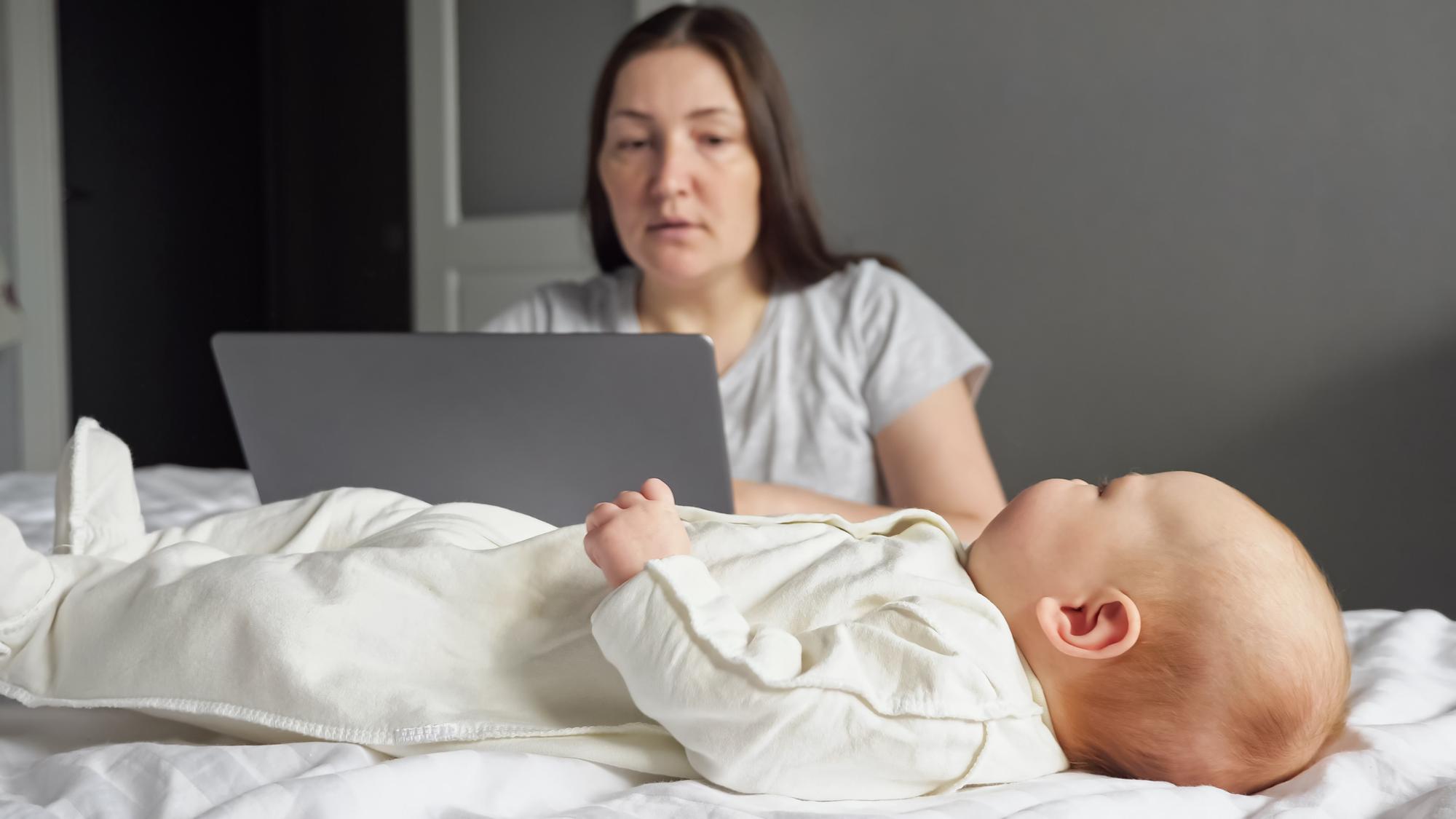 Concerned parent checking on sleeping newborn baby to monitor for warning signs and symptoms