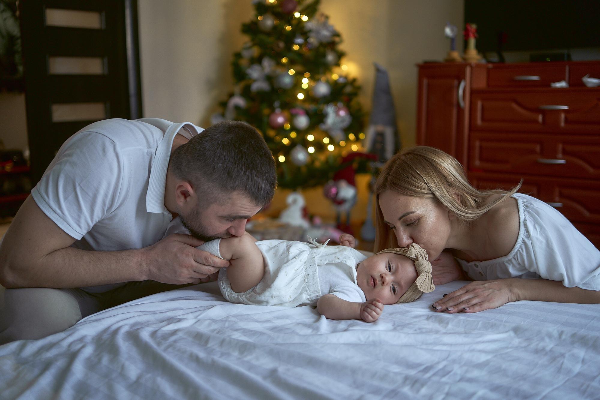 Peaceful newborn baby sleeping during first week at home with parents nearby