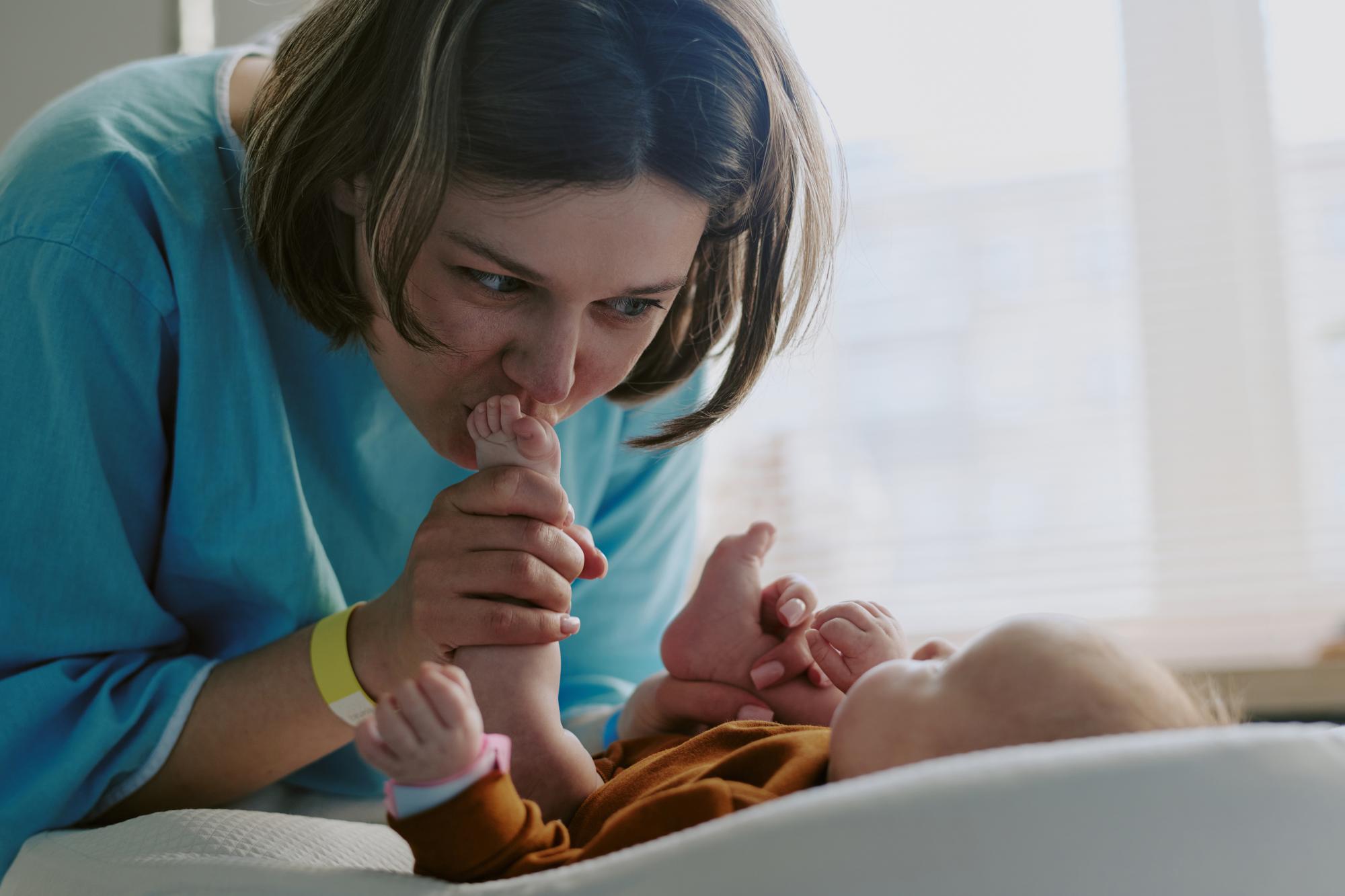 Pediatrician examining newborn baby during feeding assessment consultation