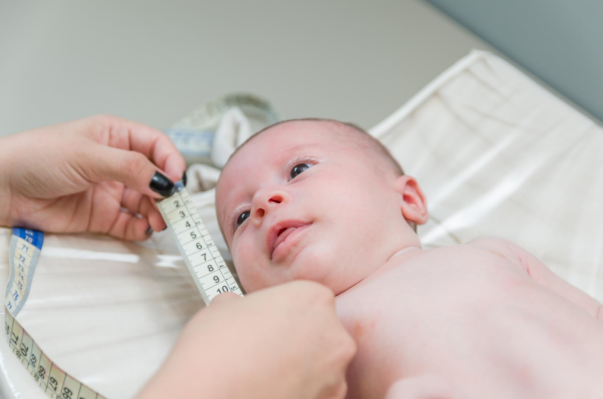 Newborn baby being weighed on medical scale during feeding assessment in Tbilisi
