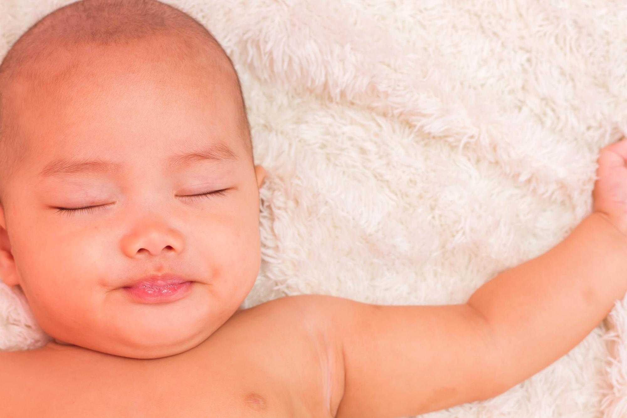 Peaceful newborn baby sleeping with normal breathing pattern