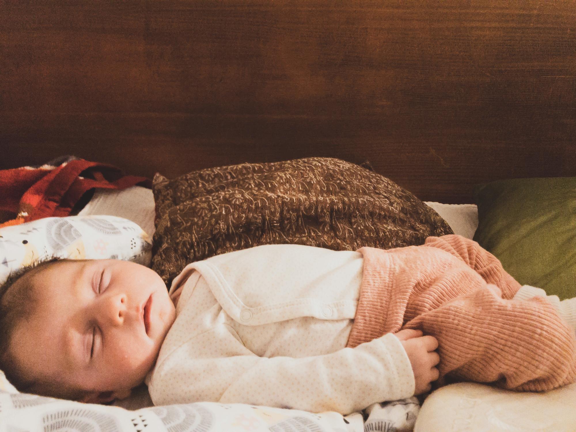 Peaceful sleeping newborn baby in safe sleep environment showing normal sleep patterns