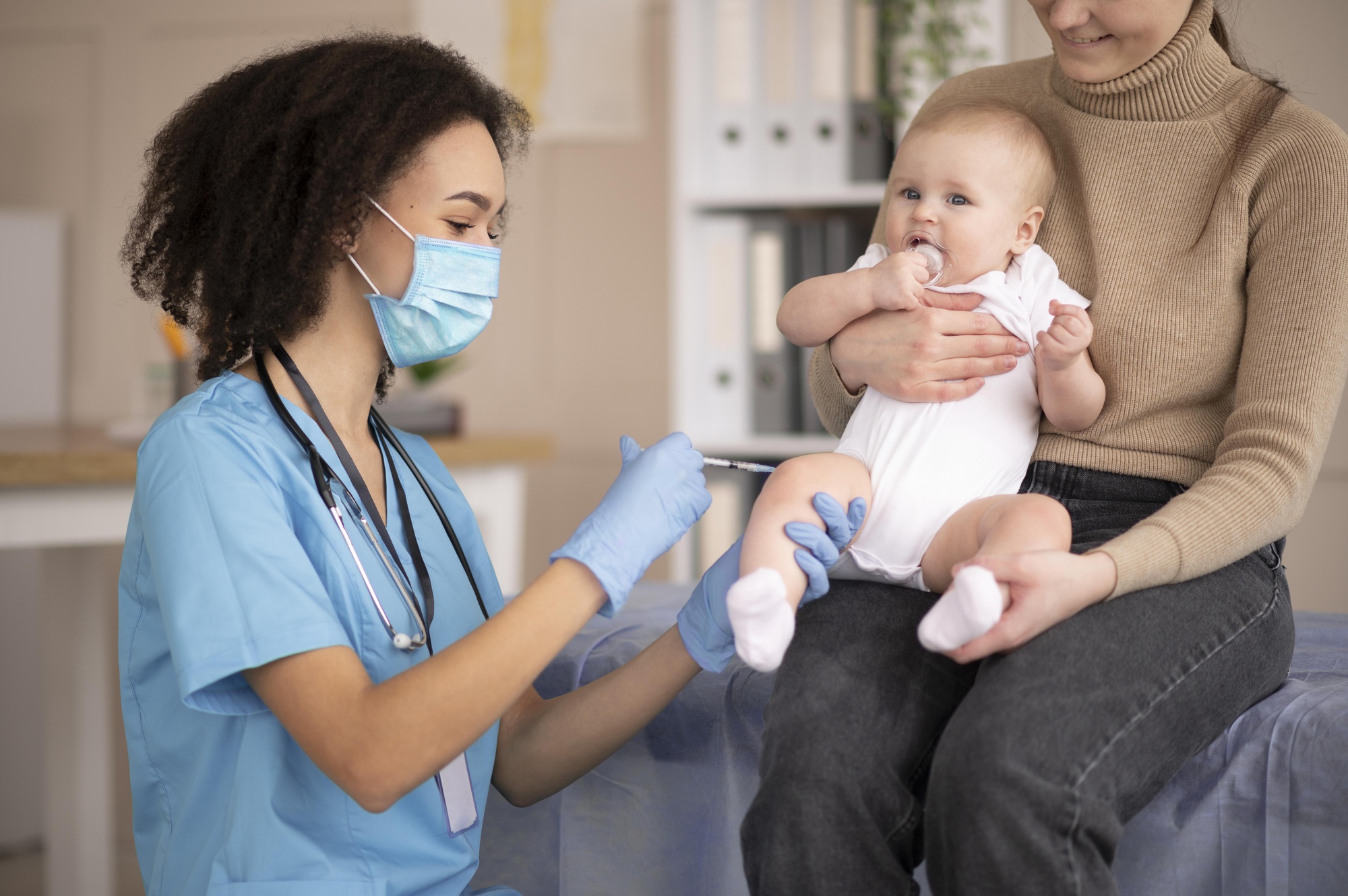 Baby receiving vaccination at pediatric clinic in Georgia with healthcare provider and parent present