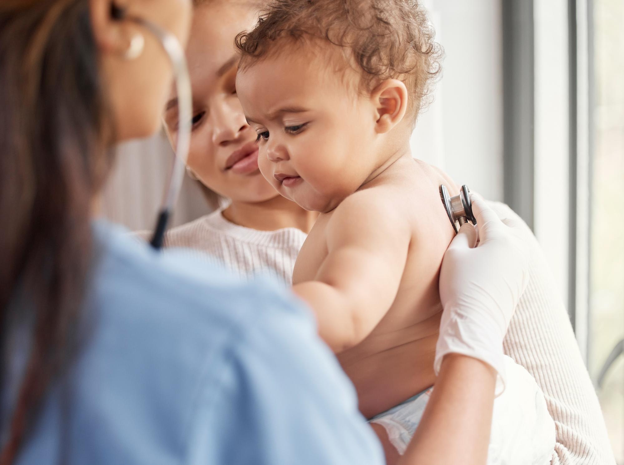 Pediatrician examining newborn skin during home visit consultation