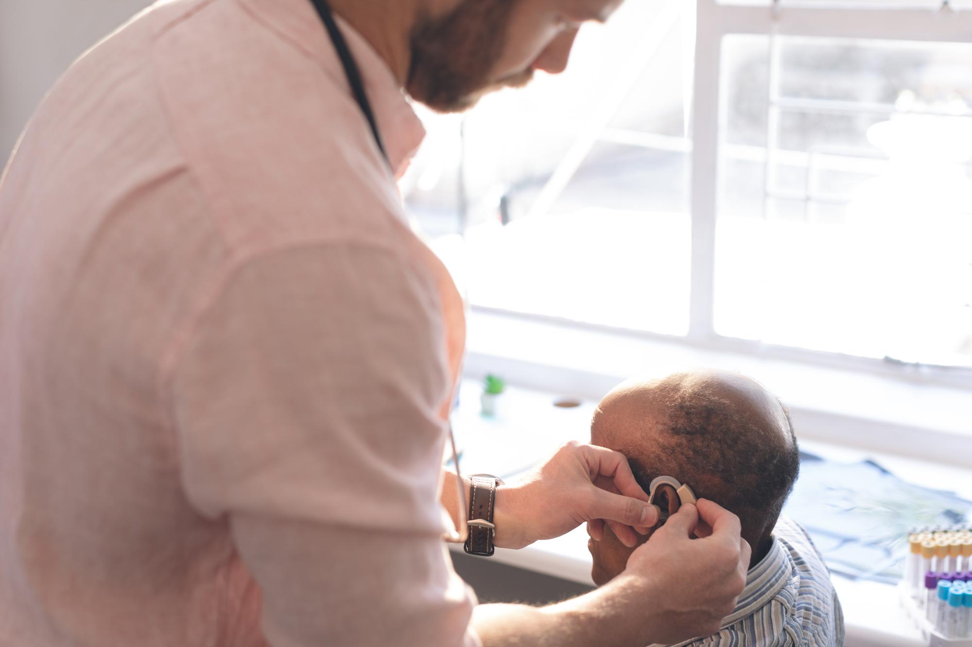 Pediatrician examining crying newborn baby during home visit consultation